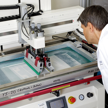 Eine Paste zur Herstellung hitzeresistenter Glaslot-Dichtungen für Festoxidbrennstoffzellen wird aufgetragen, ein Mitarbeiter kontrolliert den Prozess.