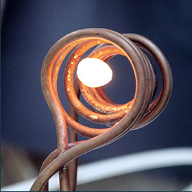 Freischwebende Metallschmelze in einem Magnetfeld innerhalb eines Geräts, das wie ein Tauchsieder aussieht.