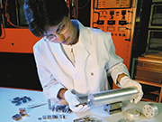 Eine Mitarbeiterin befüllt Probenbehältnisse für die Neutronenforschung